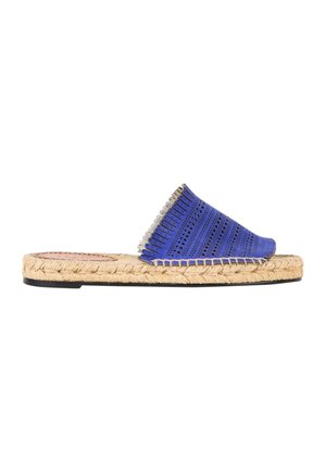 Sandalia plana tipo slide con suela de yute tejido y tira ancha azul perforada con costuras decorativas y borde con cuentas plateadas.