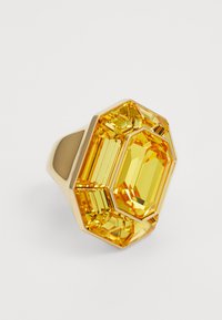 Gold-colored ring featuring a large octagonal yellow gemstone with faceted details, showcasing a geometric design and smooth band.