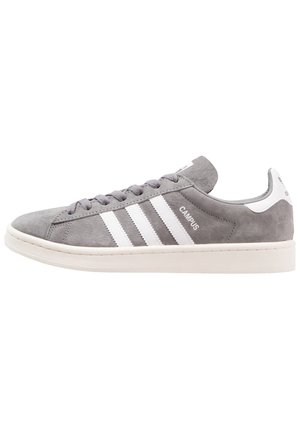 Grå ruskind Adidas Campus sneaker med hvide striber, hvid sål, snørebånd og hæltap, vist i sidelayout med venstrevendt profil.
