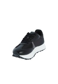 Zapatilla negra con un upper sintético texturizado, acentos de malla, una entresuela blanca y una suela negra robusta con un patrón de tracción.