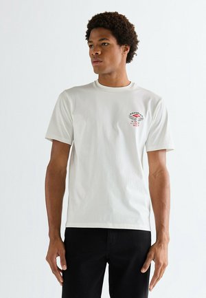 Wit katoenen t-shirt met een ronde hals, korte mouwen en een klein rood grafisch logo op de linkerborst. Glad oppervlak, casual pasvorm.