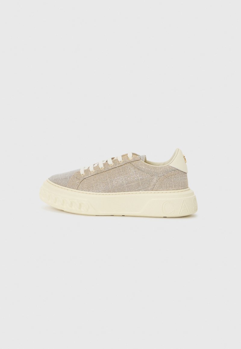 Baskets beige clair avec une tige tissée texturée, semelle en caoutchouc crème et logo embossé au niveau du talon. Présente des lacets ronds et un profil bas.