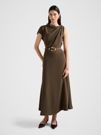 Brązowa sukienka maxi z drapowaną ramiączką, paskiem w talii i gładką fakturą. Posiada długość do kolan oraz elegancką, dopasowaną sylwetkę.