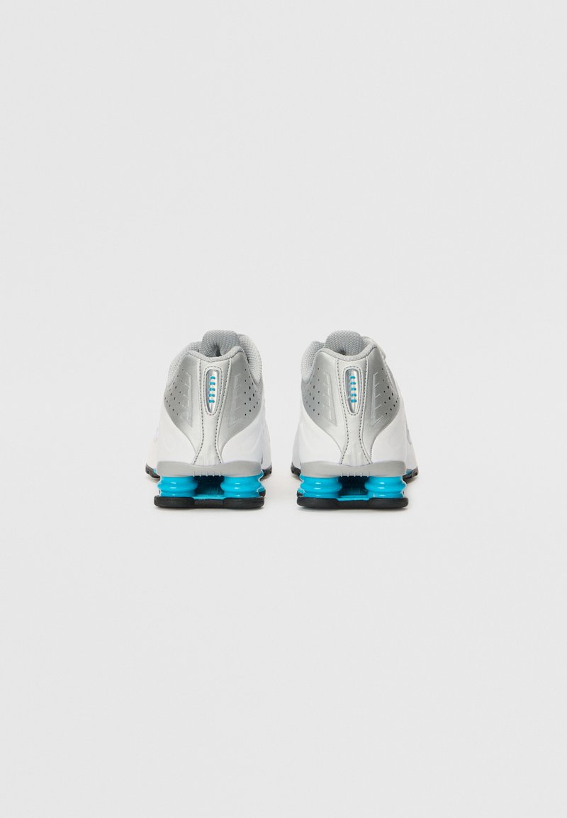 Zapatillas deportivas blancas con acentos grises, malla texturizada y amortiguación turquesa. Presentan un diseño aerodinámico con detalles perforados en los costados.