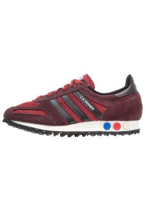Maroon retro sneaker with mesh and suede upper, black stripes, textured sole, red laces, and multicolor accents on the heel.