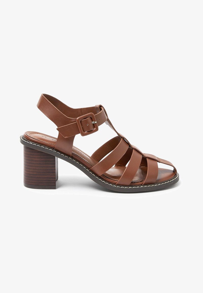 Sandale à talon marron en cuir avec talon bloc, bout ouvert, multiples brides et une grande boucle de fermeture sur la sangle de cheville.