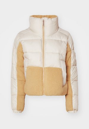 Cream and tan puffer jacket with a high collar, featuring quilted fabric and a soft, fuzzy fleece panel on the front and side.