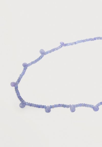 Λεπτό κολιέ με μικρές στρογγυλές μπλε χάντρες και μεγαλύτερες μπλε χάντρες σε σχήμα σταγόνας νερού, τοποθετημένες ομοιόμορφα κατά μήκος της σειράς σε λευκό φόντο.