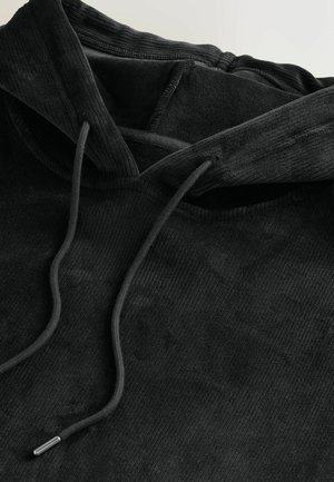 Svart huva sweatshirt gjord av ribbad tyg, med snörning med metallaglets och en strukturerad yta.