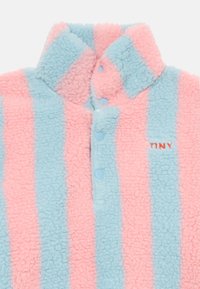Pull en polaire avec des rayures alternées rose et bleu clair, col montant, trois boutons-pression et "TINY" brodé en rouge.