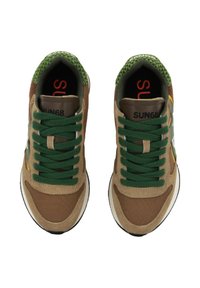 Sneakers marroni e verdi realizzati in materiali scamosciati e tessili. Presentano lacci verdi, dettagli gialli e un colletto verde con texture.