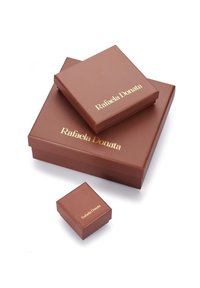 Pruuni kinkekarbid kolmes suuruses läikiva viimistlusega. Suurimal on kuldsete tähtedega kirjas "Rafaela Donata". Sile tekstuur, mustrid puuduvad.