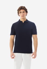Navyblaues Poloshirt mit kurzen Ärmeln und klassischem Kragen, aus glattem Stoff gefertigt und mit einem dezenten Logo auf dem Ärmel.