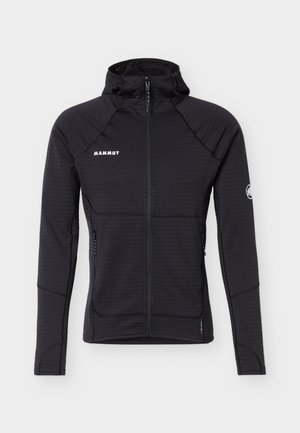 Hanorac negru cu fermoar complet, cu logo Mammut pe piept și mânecă, două buzunare cu fermoar și mâneci lungi conice cu orificii pentru degete.