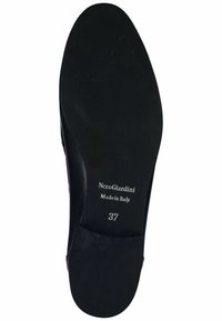 Černá kožená podrážka s embosovaným logem "NeroGiardini," "Vyrobeno v Itálii" a velikostí "37." Hladký povrch s drobnými známkami opotřebení.