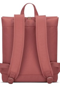 Por rózsaszínű anyagból készült hátizsák, minimalista dizájnnal, állítható pántokkal, tetején fogantyúval és sima, texturált felülettel.