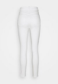 Pantalones vaqueros blancos con un diseño ajustado, fabricados en denim. Cuentan con dos bolsillos traseros y una cintura alta. Textura suave con un acabado limpio.