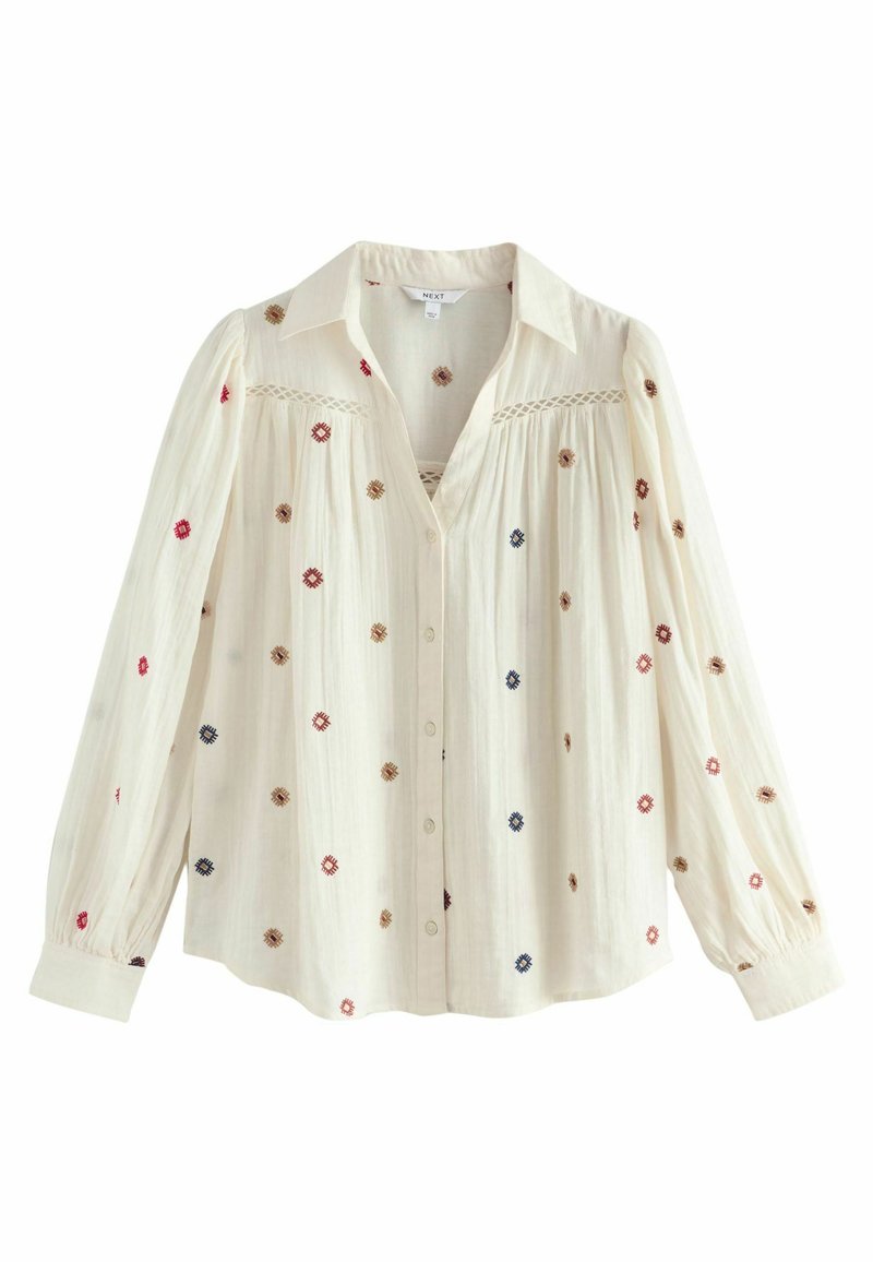 Embroidered blouse in cream fabric, featuring colorful floral patterns, a button front, and long, puffed sleeves with a collar.