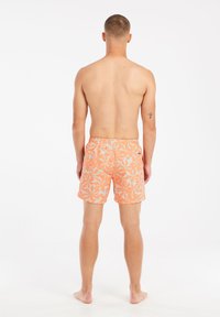 Zwemshorts voor heren in fel oranje met een wit bloemenpatroon. Elastische tailleband, geen zichtbare sluitingen. Glad materiaal met een comfortabele pasvorm.