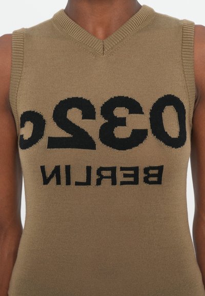 Top senza maniche lavorato a maglia in verde oliva con scollatura a V. Presenta un audace testo nero che recita "032C BERLINO," creando un design contrastante.