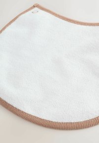 Bavoir pour bébé en éponge blanche douce avec bord côtelé marron clair et une petite fermeture à pression dans le coin supérieur.