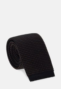 Juodas megztas kaklaraištis su tekstūruotu raštu ir subtiliomis rudomis detalėmis. Suvyniota forma su elastiniu galu, užtikrinančiu tvirtą prigludimą.