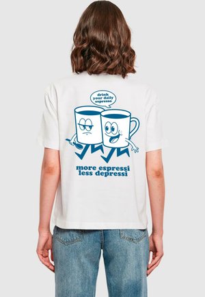 Valkoinen T-paita, jossa on sininen graafinen kuva kahdesta kahvimukista, joissa on kasvot. Teksti lukee "juo päivittäinen espresso" ja "enemmän espressoa, vähemmän masennusta."
