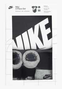 Detská súprava Nike v troch kusoch pre novorodencov obsahuje čierne body, sivé papučky a čiapku, všetko s logom Nike v kontrastných farbách.