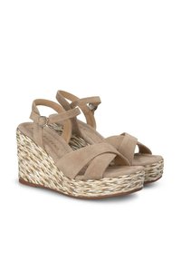 Sandalias de cuña de ante beige con tiras entrecruzadas y hebilla ajustable en el tobillo; base tejida con textura similar a cuerda; plantilla acolchada.