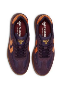Lila Turnschuhe mit orangenen Akzenten, bestehend aus einer Kombination von Wildleder und Mesh-Material, runder Zehenpartie und flacher Gummisohle. Logo auf der Zunge und der Innensohle.