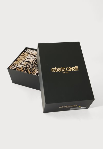 Μαύρο κουτί με χρυσό κείμενο "roberto cavalli home", μερικώς ανοιχτό που δείχνει ύφασμα με λεοπάρ μοτίβο στο εσωτερικό, σε λευκό φόντο.