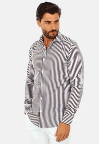Camicetta a maniche lunghe a righe bianche con sottili righe verticali marroni, dotata di colletto button-down e bottoni bianchi.