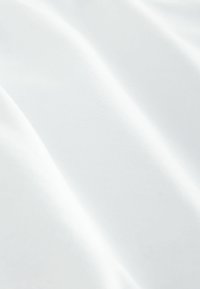 Tela blanca con una textura suave y ligeramente brillante, que muestra pliegues suaves y un acabado uniforme, indicando un material ligero.