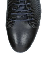 Czarne skórzane buty z gładkim noskiem i perforowanym wzorem na górze. Posiadają ciemnoniebieskie sznurowadła przeprowadzone przez pięć przelotek.