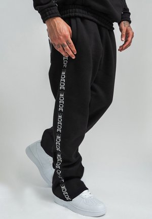JOGGING MIT LOGOTAPE UND KRONE PRINT BAGGY STYLE - Jogginghose - schwarz