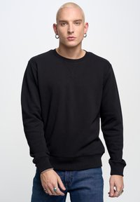 Felpa nera con colletto tondo realizzata in tessuto misto cotone. Presenta polsini e orlo a costine, con un design classico a pullover.