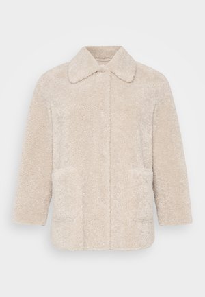 Beige fuskepelsjakke med kragehals, lange ermer og to frontlommer. Teksturen er myk og fluffy.