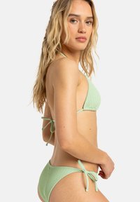 Grön mintfärgad bikini med ribbad struktur. Knytning i nacken och på sidan, med mjukt tyg och triangeldesigntopp. Enkel och funktionell stil.