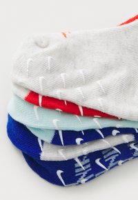 Fünf Paar Nike-Socken in Weiß, Rot, Hellblau und Blau, mit strukturierten Mustern und markanten Branding-Elementen.