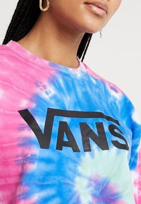 Tie-dye t-shirt i pink, blå og grønne nuancer med et stort sort "VANS" logo. 100% bomulds materiale; kortærmet og rund hals design.