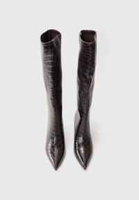 Bottes marron, à hauteur de genou, en faux cuir croco texturé. Bout effilé et forme sculptée avec une doublure intérieure lisse.