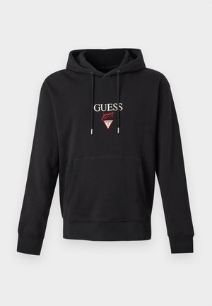 Schwarzer Kapuzenpullover mit Fronttasche, metallbestückten Kordeln und "GUESS Jeans" Logo mit rotem Dreiecks-Emblem auf der Brust.