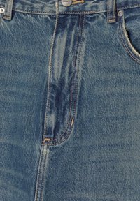 Farkut haalistuneessa sinisessä värissä, korkealla vyötäröllä, näkyvillä saumoilla, viiden taskun mallilla ja hopeanvärisellä napilla ylhäällä.