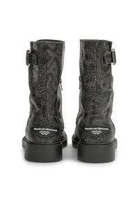 Botas de tobillo de cuero negro con un estampado de serpiente texturizado, un tacón bajo cuadrado, cremalleras traseras y un emblema en el tacón.