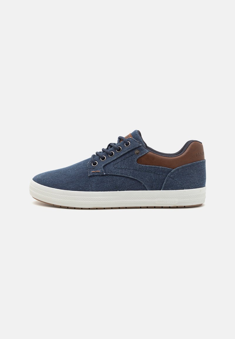 Blue denim sneakers with a light gray rubber sole, brown leather accents, round laces, and a low-top design. Textured fabric and stitching details.