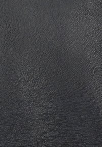 Czarna skórzana tekstura o ziarnistej powierzchni z subtelnymi różnicami w odcieniach i ogólnie gładkim wykończeniu.