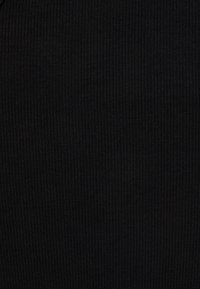 Černá žebrovaná tkanina s jemnou texturou, obsahující úzké vertikální pruhy, vhodná pro různé oděvní kousky. Žádné kovové součásti nebo akcenty nejsou viditelné.