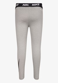 Gray leggings made of stretch fabric, featuring a black Nike logo on the waistband and a black side accent on the leg.