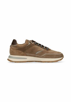 Bruine suède sneaker met beige rubberen zool, donkerbruine hieltab, metalen oogjes en donkerbruine veters op een witte achtergrond.