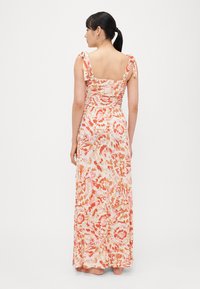 Φλοράλ μάξι φόρεμα από απαλό ύφασμα, με τετράγωνη λαιμόκοψη και ρυθμιζόμενους ιμάντες στους ώμους, με πολύχρωμο μοτίβο σε ροζ και πορτοκαλί αποχρώσεις.